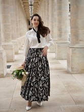 a lady wears a white blouse with a maxi floral printed skirt